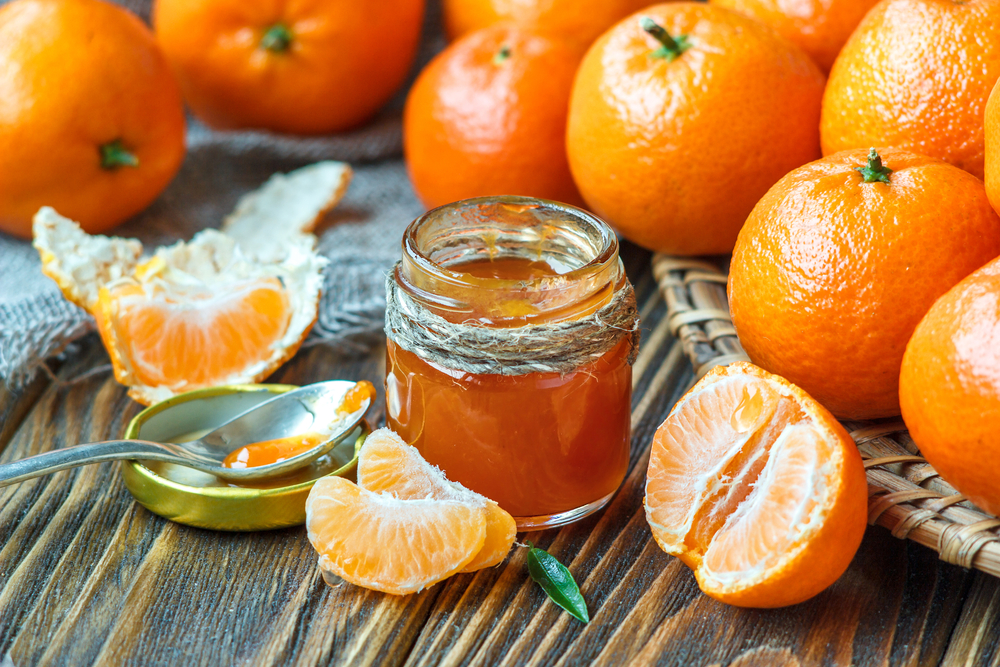 Homemade,tangerine,jam,in,glass,jar,with,fruit,around,on