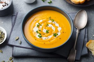 Pumpkin,,carrot,cream,soup,in,a,bowl.,grey,background.