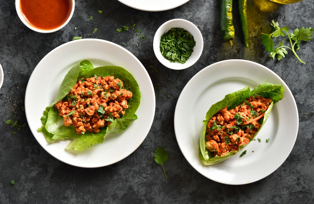 Asian,minced,meat,lettuce,wraps,on,plate,over,dark,stone