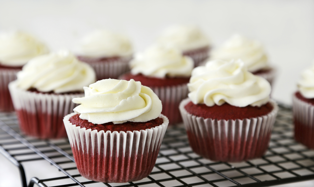 Red,velvet,cupcakes,with,cream,cheese,frosting,on,a,rack